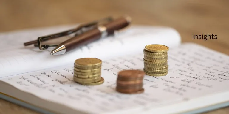 Money piles resting on top of a journal.